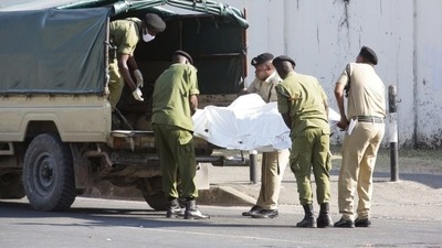 Tanzanian security forces remove the slain body of an attacker who was wielding an assault rifle, outside the French embassy in the Salenda area of Dar es Salaam, Tanzania, (Reuters)