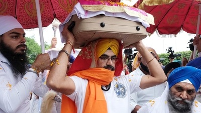 A copy of the Guru Granth Sahib, the central holy scripture of Sikhism, being carried out from the airport in New Delhi on Tuesday. (Bloomberg) A copy of the Guru Granth Sahib, the central holy scripture of Sikhism, being carried out from the airport in New Delhi on Tuesday. (Bloomberg)
