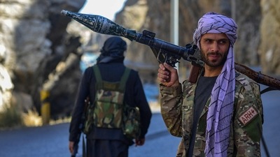 Afghan resistance movement and anti-Taliban uprising forces patrol along a road at the Rah-e Tang in Panjshir province. (AFP) Afghan resistance movement and anti-Taliban uprising forces patrol along a road at the Rah-e Tang in Panjshir province. (AFP)