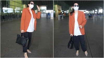 Karisma chose a rust-orange coloured oversized blazer for her flight out of Mumbai. The notch-lapel collar jacket featured mock pockets on the front and long sleeves. (HT Photo/Varinder Chawla)