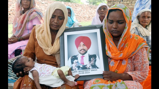 Family members of Manpreet Singh, who died of drug overdose on August 15, show his portrait in Bathinda on Wednesday. (Sanjeev Kumar/HT)