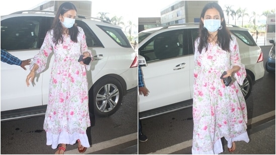 Rakul's airport look featured a white anarkali adorned with pink and green floral print. The kurta had a billowy silhouette with a cinched-in detail at the waist and bell sleeves.(HT Photo/Varinder Chawla)