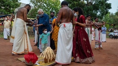 A child wearing mask as a precaution against Covid-19 watches elders perform a ritual during Onam festival in Kochi, Kerala. (AP Photo) A child wearing mask as a precaution against Covid-19 watches elders perform a ritual during Onam festival in Kochi, Kerala. (AP Photo)