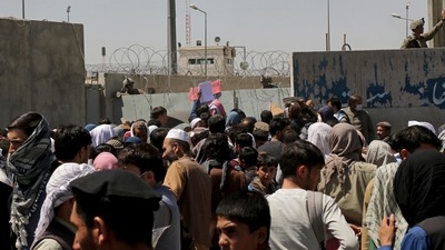 US soldiers stand inside the airport wall as hundreds of people gather near an evacuation control checkpoint on the perimeter of the Hamid Karzai International Airport, in Kabul, Afghanistan. (AP) US soldiers stand inside the airport wall as hundreds of people gather near an evacuation control checkpoint on the perimeter of the Hamid Karzai International Airport, in Kabul, Afghanistan. (AP)