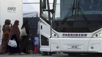 Refugees from Afghanistan and Canadian citizens board a bus after being processed at Pearson Airport in Toronto, Canada. (AP) Refugees from Afghanistan and Canadian citizens board a bus after being processed at Pearson Airport in Toronto, Canada. (AP)