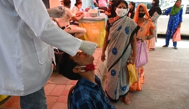 A health worker takes a swab sample from a youth to test for the Covid-19 coronavirus at a testing center in New Delhi. ( AFP) A health worker takes a swab sample from a youth to test for the Covid-19 coronavirus at a testing center in New Delhi. ( AFP)