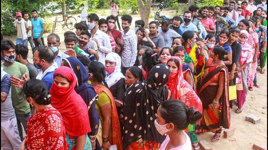 Beneficiaries not adhering to social distancing norms, wait in queues to receive Covid-19 vaccine dose, at a government school turned vaccination centre in Gurugram on Thursday. (PTI)