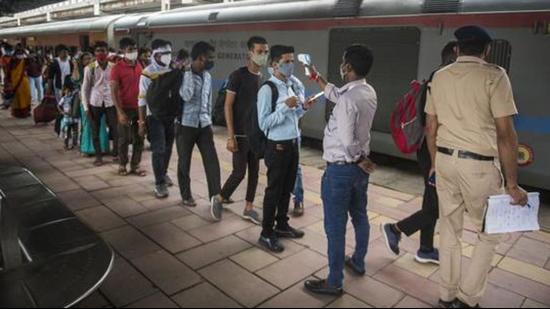 A healthcare worker checks temperatures before the Covid-19 test of passengers arriving in outstation trains at Dadar station in Mumbai on Thursday. (HT PHOTO.)