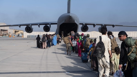 This handout photo courtesy of the US Air Force shows loadmasters and pilots assigned to the 816th Expeditionary Airlift Squadron, load passengers aboard a US Air Force C-17 Globemaster III in support of the Afghanistan evacuation at Hamid Karzai International Airport (HKIA) in Afghanistan on August 24, 2021. (AFP)