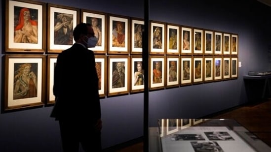 A women takes a photo of the artwork 'Demons of the Hour' by artist Werner Peiner at the exhibition 'Divinely Gifted List' at the German Historic Museum in Berlin, Germany. The exhibition at the German Historical Museum traces the lives and creations of several artists who made it onto the so-called 'Divinely Gifted List' from 1944, which was compiled on behalf of Adolf Hitler and other top Nazis.(AP Photo/Markus Schreiber)