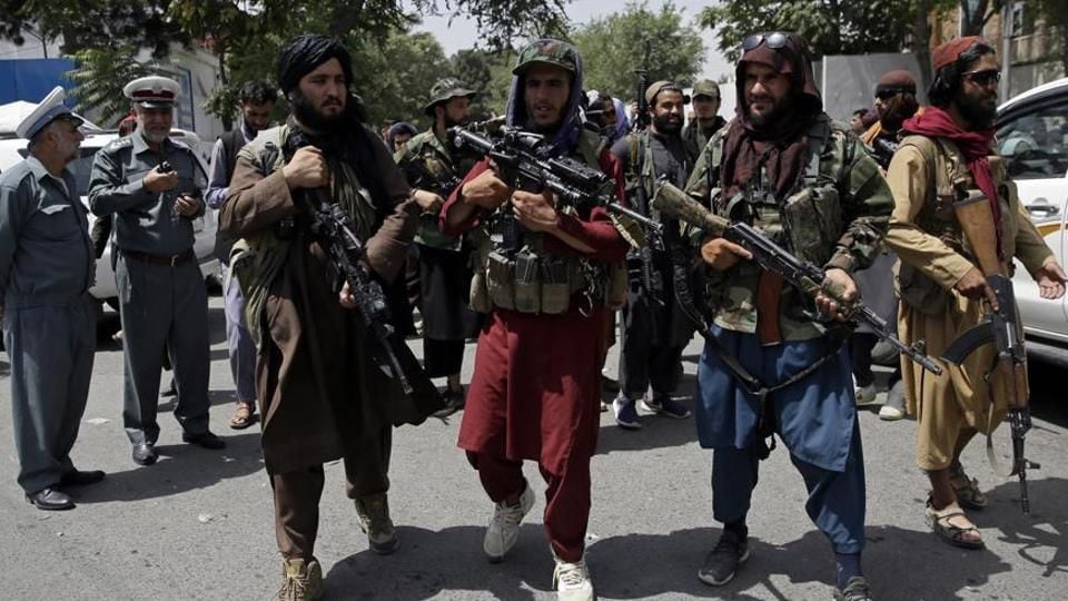 Taliban fighters brandishing weapons on the streets of Kabul