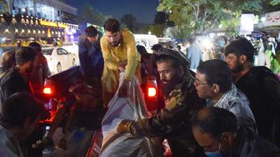 Volunteers and medical staff unload bodies from a pickup truck outside a hospital after two powerful explosions, which killed at least six people, outside the airport in Kabul on August 26. (AFP) Volunteers and medical staff unload bodies from a pickup truck outside a hospital after two powerful explosions, which killed at least six people, outside the airport in Kabul on August 26. (AFP)
