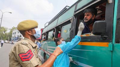A health worker takes swab sample of a bus driver for Covid test in Jammu on Friday. (PTI)