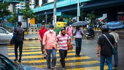 People wearing face masks as a precaution against the coronavirus walk at a pedestrian crossing in Kochi. (AP)