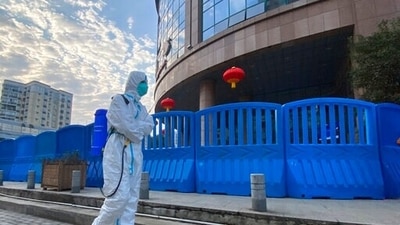 A worker in protectively overalls and carrying disinfecting equipment walks outside the Wuhan Central Hospital. (AP) A worker in protectively overalls and carrying disinfecting equipment walks outside the Wuhan Central Hospital. (AP)