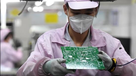 An employee inspects a circuit board on the controller production line at a factory in Wuhan, Hubei province, China on August 16, 2021. (REUTERS)