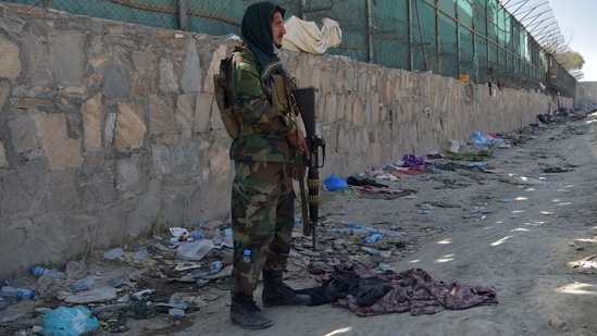 A Taliban fighter stands guard at the site of the attacks, in Kabul airport on Friday.(AFP)