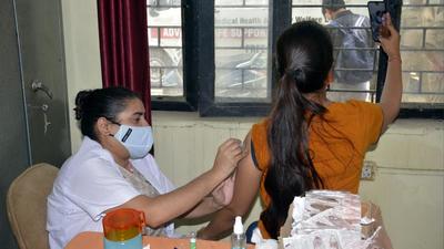 A young woman takes a selfie as the health worker inoculates her with Covid-10 coronavirus vaccine, Ghaziabad, Uttar Pradesh, August 27, 2021 (Sakib Ali /Hindustan Times)