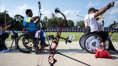 India's Rakesh Kumar (L) and Iran's Ramezan Biabani compete in the men's archery individual ranking round during the Tokyo 2020 Paralympic Games (AFP)