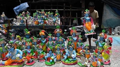 A young boy fills his cart with idols of Lord Krishna and put them on display for sale ahead of the 'Janmashtami' in Chennai. (AFP)