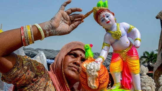 A woman in Amritsar gives finishing touches to an idol of Lord Krishna in the scotching heat.(PTI)