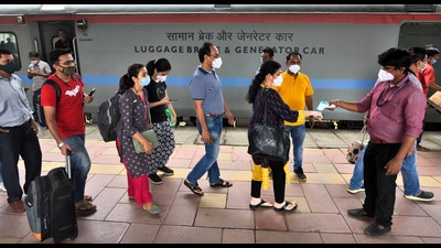 A health worker screens passengers at Dadar station on Sunday. (Satish Bate/HT) A health worker screens passengers at Dadar station on Sunday. (Satish Bate/HT)