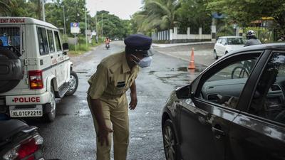 A policeman checks the occupants of a car as he enforces a weekend lockdown to curb the spread of Covid-19 in Kochi on Sunday. The state reported 29,836 new Covid cases. (AP) A policeman checks the occupants of a car as he enforces a weekend lockdown to curb the spread of Covid-19 in Kochi on Sunday. The state reported 29,836 new Covid cases. (AP)