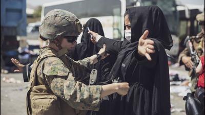 A US Marine checks a woman during an evacuation at Hamid Karzai International Airport, Kabul, Afghanistan, on Saturday. (REUTERS) A US Marine checks a woman during an evacuation at Hamid Karzai International Airport, Kabul, Afghanistan, on Saturday. (REUTERS)