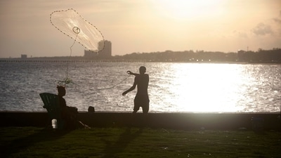 A man fishes at the old Broadwater Marina in Biloxi, Mississippi on August 28, ahead of Hurricane Ida. (AP) A man fishes at the old Broadwater Marina in Biloxi, Mississippi on August 28, ahead of Hurricane Ida. (AP)