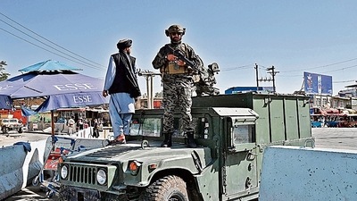 A Taliban Badri fighter stands guard at the main entrance gate of Kabul airport. (AFP)