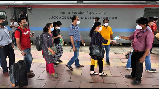 A health worker screens passengers at Dadar station on Sunday. (Satish Bate/HT)