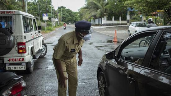 A policeman checks the occupants of a car as he enforces a weekend lockdown to curb the spread of Covid-19 in Kochi on Sunday. The state reported 29,836 new Covid cases. (AP)