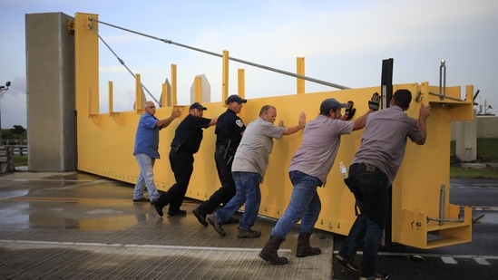 Crews re-open a levee flood gate across Louisiana Route 1 after motorists missed a closure deadline and became trapped ahead of Hurricane Ida in Golden Meadow, Louisiana, U.S., on August 28.(Bloomberg)
