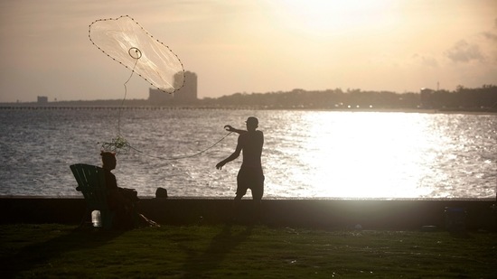 A man fishes at the old Broadwater Marina in Biloxi, Mississippi on August 28, ahead of Hurricane Ida.(AP)