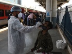 A BMC health worker collects swab samples for Covid-19 test of commuters arriving from outstation trains at Dadar station, in Mumbai. A BMC health worker collects swab samples for Covid-19 test of commuters arriving from outstation trains at Dadar station, in Mumbai.