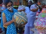 A woman buys an earthen pot to celebrate Dahi Handi ahead of the Gokulashtami festival from a shop at Jambhali Naka Market, in Thane, Mumbai, on Saturday. 