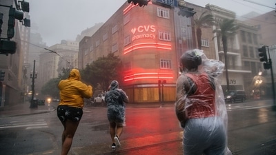 A group of people cross an intersection during Hurricane Ida in New Orleans, Louisiana on August 29. The levees, pumps and other infrastructure rebuilt after Hurricane Katrina in 2005 storm are being put to their biggest test yet. Louisiana’s hospitals are already overwhelmed with more than 2,600 coronavirus patients, Bloomberg reported. (Brandon Bell / AFP) A group of people cross an intersection during Hurricane Ida in New Orleans, Louisiana on August 29. The levees, pumps and other infrastructure rebuilt after Hurricane Katrina in 2005 storm are being put to their biggest test yet. Louisiana’s hospitals are already overwhelmed with more than 2,600 coronavirus patients, Bloomberg reported. (Brandon Bell / AFP)
