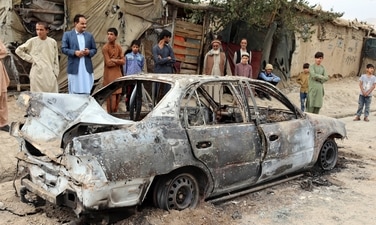 Locals view a vehicle damaged by a rocket attack in Kabul, Afghanistan. (AP/PTI)