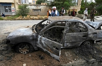 Taliban fighters investigate a damaged car after multiple rockets were fired in Kabul, (AFP Photo) Taliban fighters investigate a damaged car after multiple rockets were fired in Kabul, (AFP Photo)