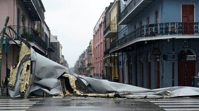 A section of roof that was blown off of a building in the French Quarter by Hurricane Ida winds blocks an intersection. (AP Photo)