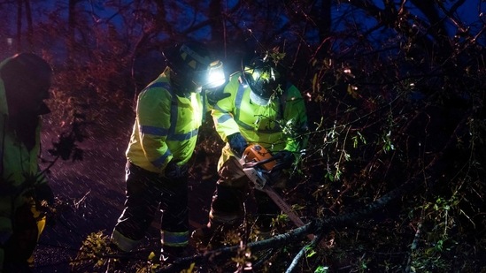 Montegut and Bourg firefighters cut through trees on the road in Bourg, Louisiana as Hurricane Ida passes on August 29. Ida struck New Orleans on the 16th anniversary of Hurricane Katrina, the costliest tropical cyclone in US history that left much of the city in ruins.(Mark Felix / AFP)