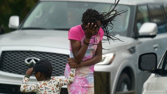A woman and a child hold on amid strong winds and rain caused by Hurricane Ida, in New Orleans, on August 29. Ida’s 150-mile-per-hour winds tie Louisiana’s hurricane record set by Laura in 2020 and a 19th century storm, Bloomberg reported.(AP / PTI)