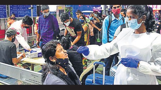 A BMC health worker collects swab sample of a passenger at CSMT in Mumbai on Monday. (Bhushan Koyande/ HT)