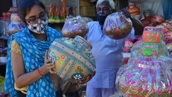 A woman buys an earthen pot to celebrate Dahi Handi ahead of the Gokulashtami festival from a shop at Jambhali Naka Market, in Thane, Mumbai, on Saturday. (HT photo)