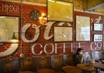 A woman wearing a face mask sits in a cafe in a neighborhood popular with tourists in central Beijing