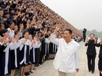 Kim Jong Un waves as he attends a photo session with participants during Youth Day celebrations. 