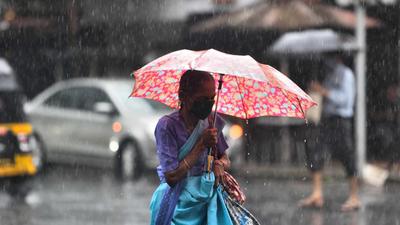 A woman walks amid heavy rain at Vile Parle. (Satish Bate/HT PHOTO)
