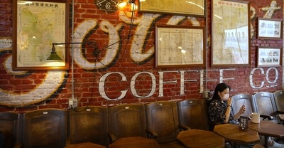 A woman wearing a face mask sits in a cafe in a neighborhood popular with tourists in central Beijing (AP) A woman wearing a face mask sits in a cafe in a neighborhood popular with tourists in central Beijing (AP)