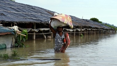 A man with his belongings wades through a flood-affected area due to heavy rainfall, in Morigaon on Monday. (ANI) A man with his belongings wades through a flood-affected area due to heavy rainfall, in Morigaon on Monday. (ANI)