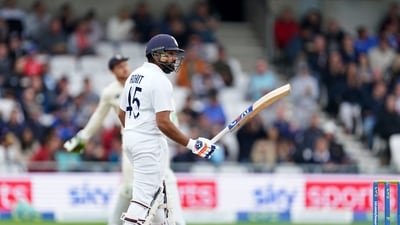 India's Rohit Sharma raises his bat to celebrate scoring fifty runs. (AP)